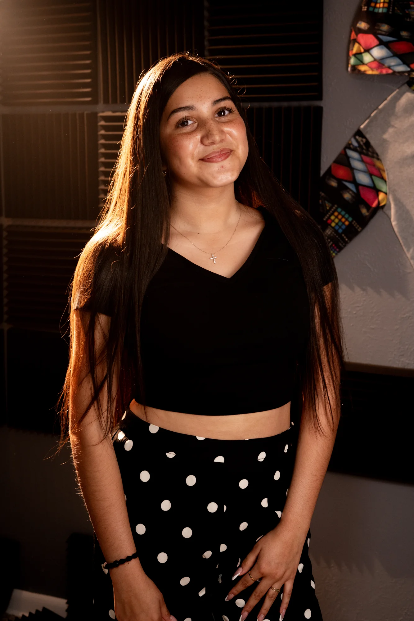 Abigail V. photographed in the studio, standing in front of acoustic paneling.